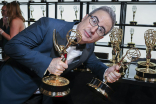 John Oliver from Last Week Tonight With John Oliver picks up his award backstage at the 75th Emmy Awards